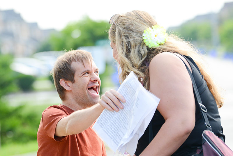 Young man with Downs Syndrome giving a hug to his female friend.